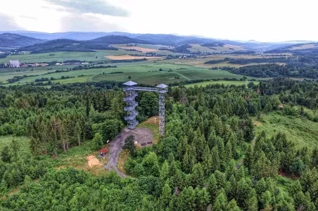 Výhledová věž v lese s panoramatickým výhledem na krajinu.