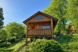 Wooden glamping cabin on hillside