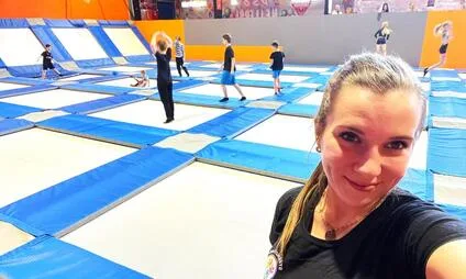 Žena se fotí v pražském skákacím centru s trampolínami.