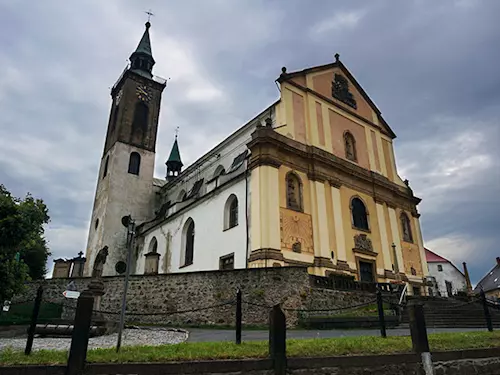 Historický kostel v Mikulášovicích na vyvýšeném kamenném podstavci.