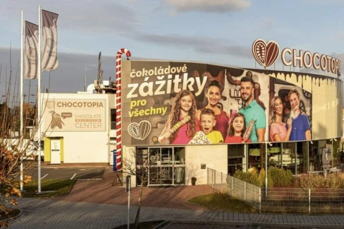 Velký plakát s rodinou na budově továrny čokolády.