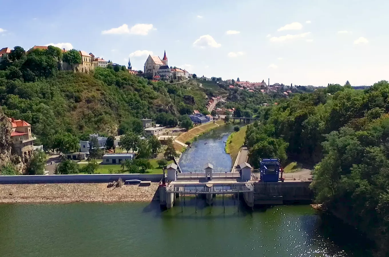 Pohled na město Znojmo s řekou a vodní nádrží v popředí.