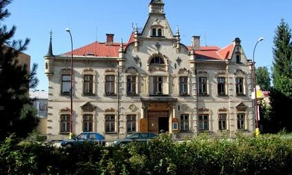Historická budova ve Svitavách s červenou střechou.