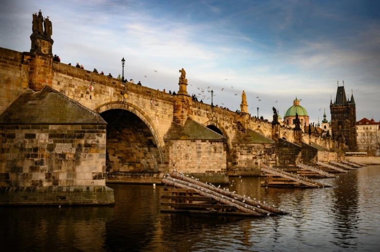 Karlův most v Praze s sochami na řece Vltavě.