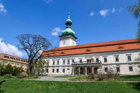 Historická budova s věží ve Valašském Meziříčí na modré obloze.