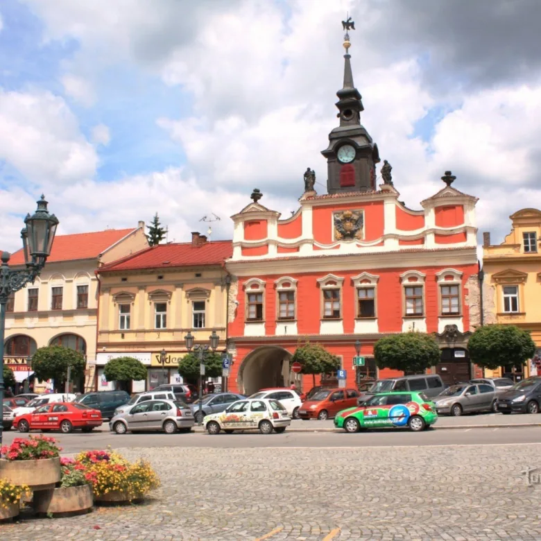 Historické radnice na náměstí v Chrudimi s parkujícími auty.