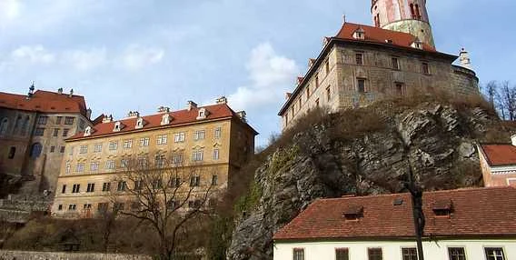 Zámek v Českém Krumlově na skále s červenými střechami.