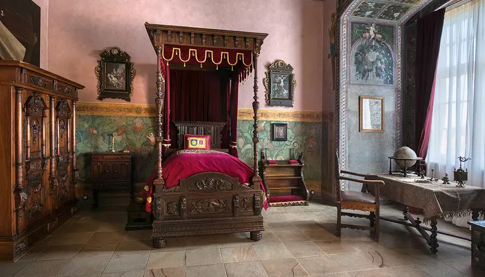 Historická ložnice v zámku s postelí na čtyřech sloupech.