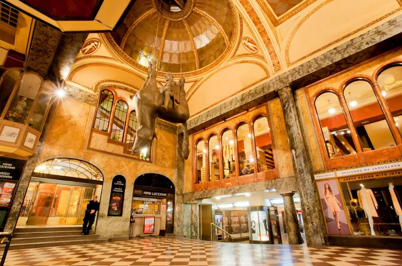 Vnitřní síň pasáže Lucerna s jezdeckou sochou pod kupolí.
