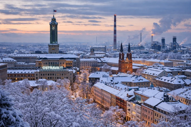 Zasněžená panorama ostravského města s kostelem a továrnami.