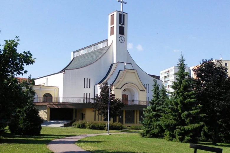Moderní kostel v Otrokovicích na pozadí zelené zahrady.