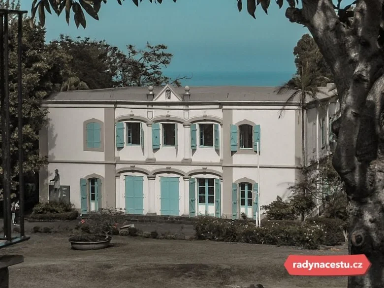Historická koloniální budova na ostrově Réunion s modrými okenními křídly.