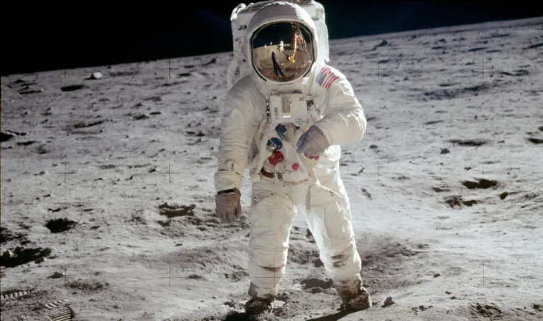 Astronaut v tutech na povrchu Měsíce při přistání.