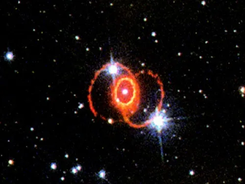 Červený prstenec zbytků supernovy na tmavém pozadí hvězd.