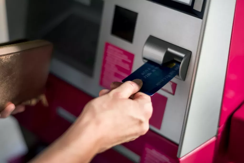 Ruka vkládá kartu do bankomatu při založení účtu.