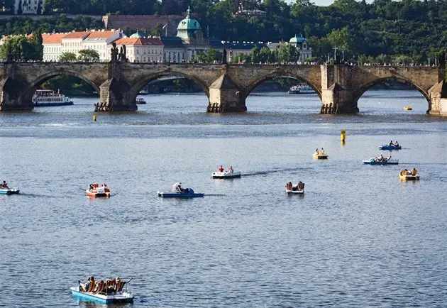 Pedal boats on river with bridge