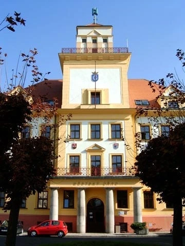 Zámek v Krasicích s žlutou fasádou a sloupovou předsíní.