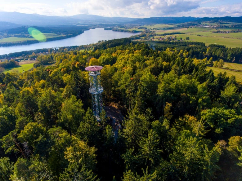 Věž rozhledna v lese s výhledem na jezero