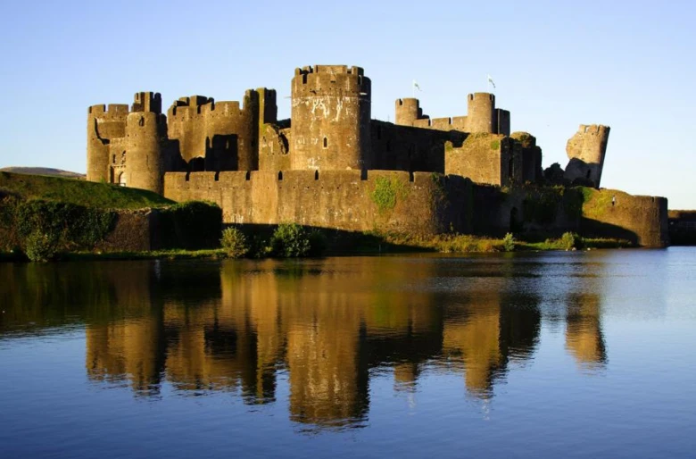 Zámek Caerphilly ve Walesu odražený v vodě.