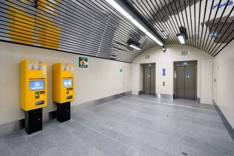 Vnitřní prostor metra s automaty na jízdenky a výtahy.