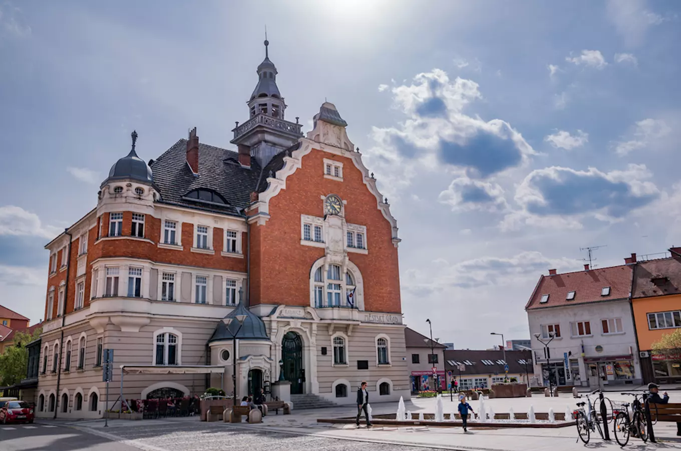 Historická radnice v Hodoníně na náměstí s lidmi kolem.