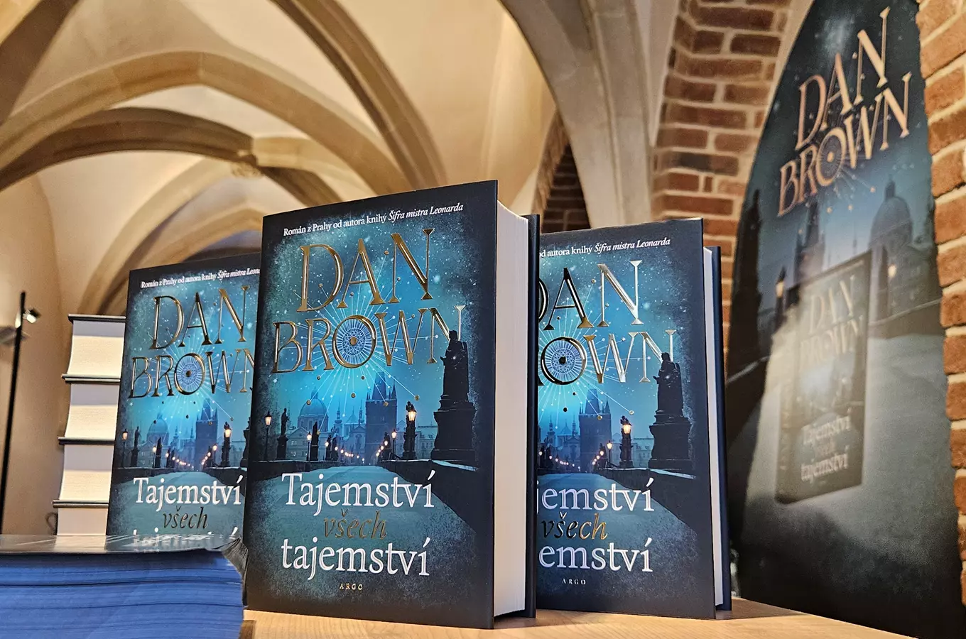 Kniha Dana Browna Tajemství všech tajemství na stolu v historické budově.