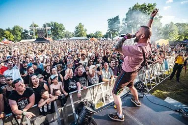 Hudební festival s velkou davem na venkovním pódiu.