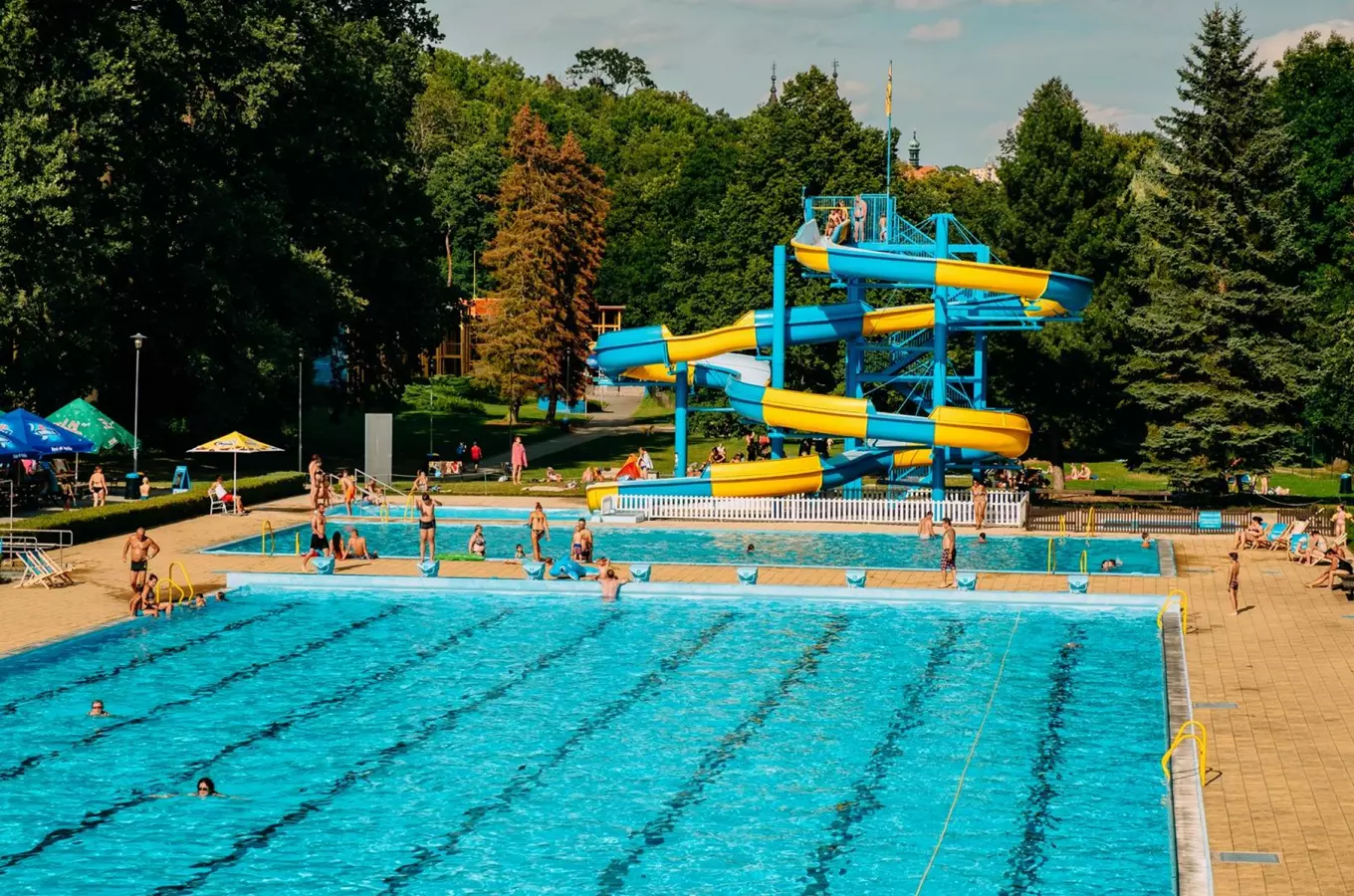 Venkovní bazén s vodními skluzavkami v koupališti Polanka.