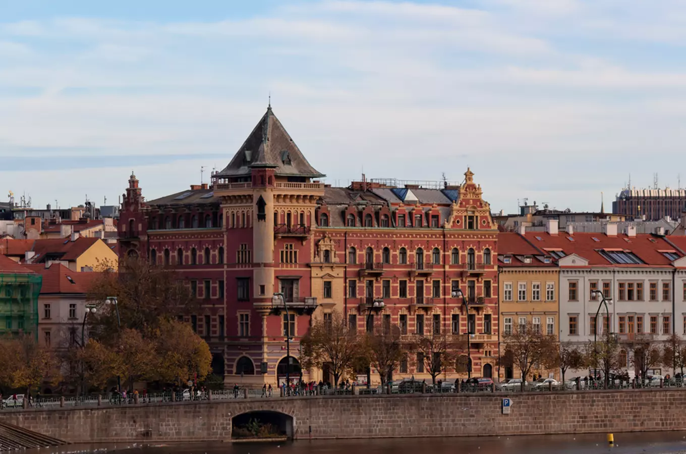 Palác Bellevue v Praze na břehu řeky s věží.