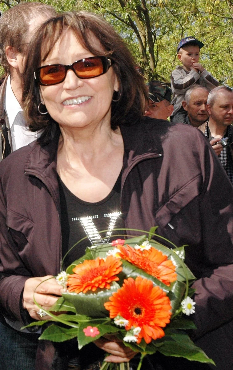 Marta Kubišová s květinami na akci venku.