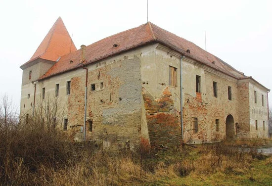 Zámek Jaroslavice v ruinách na pozadí zasněné krajiny.