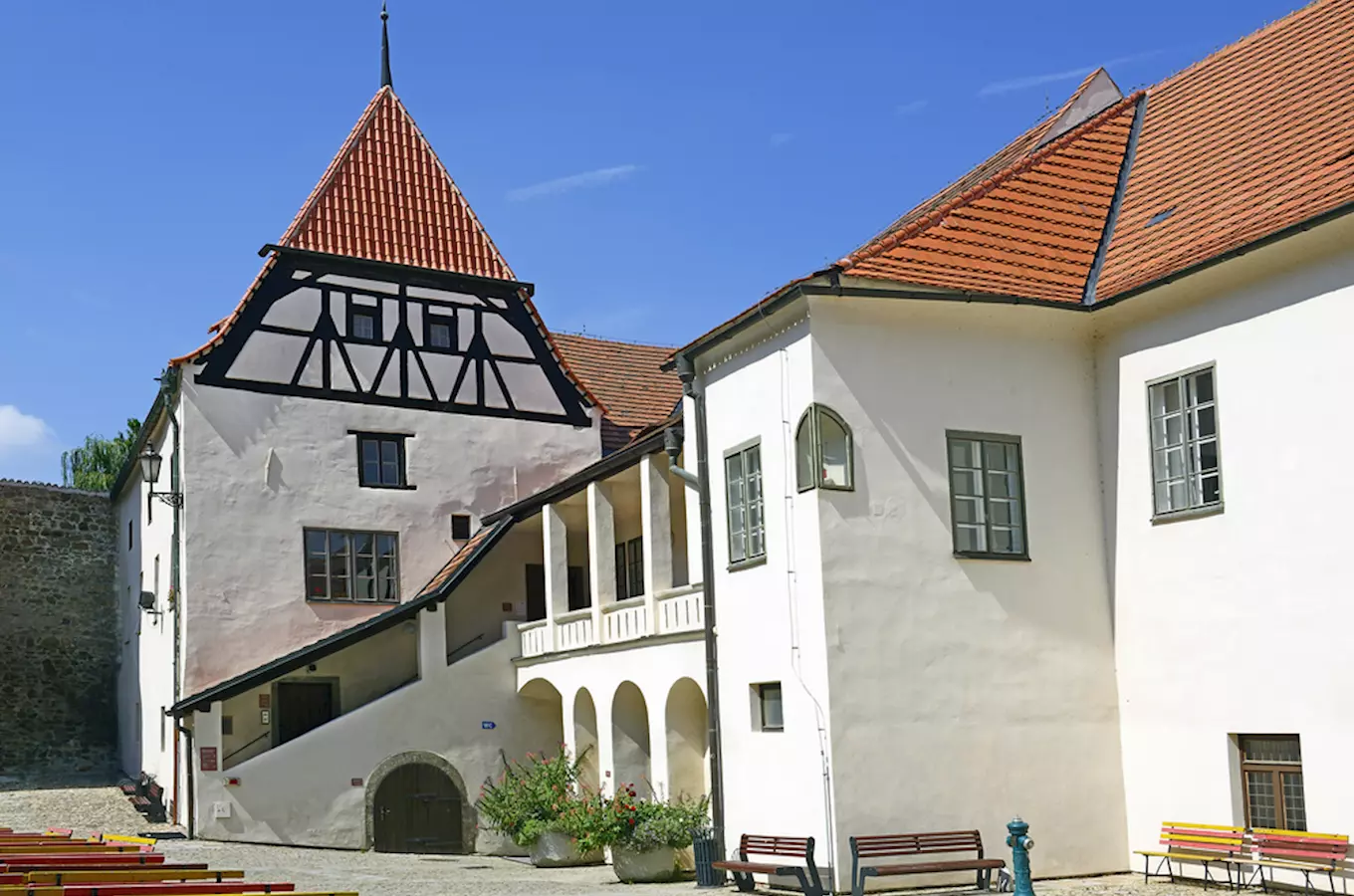 Historická budova s arkádami v Strakonicích na slunný den.