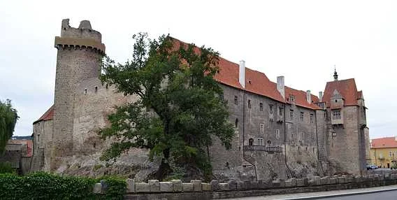 Historické hradní komplex v Volyně s věží a stromem.