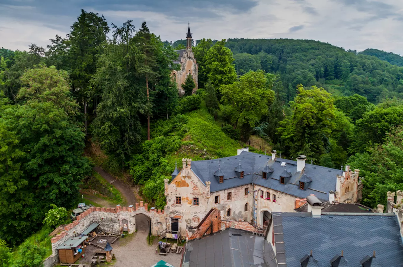 Pohled na zříceninu hradu Horní Hrad s kaplí v lese.