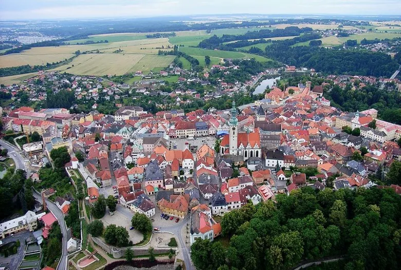 Pohled z letadla na historické město Tábora s kostelem a poli.