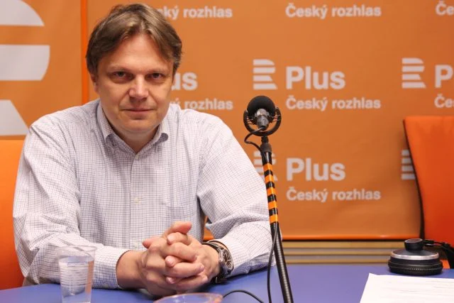 Pavel Kohout sedící u mikrofonu v studiu Českého rozhlasu.