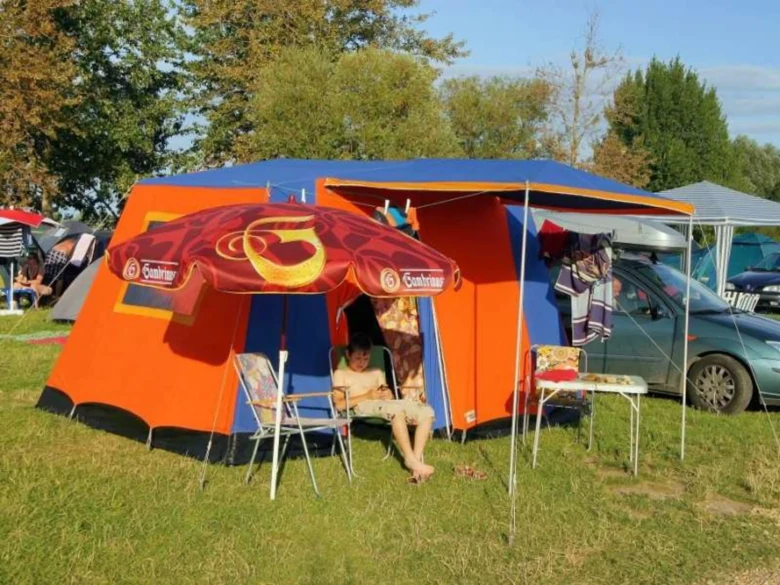 Camping tent with umbrella and chairs