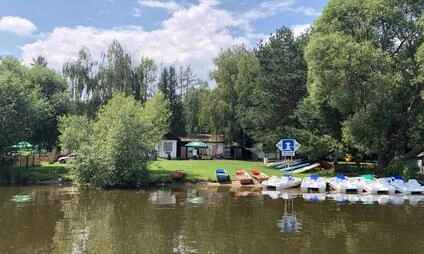 Řada barevných šlapadel u břehu jezera v Praze.