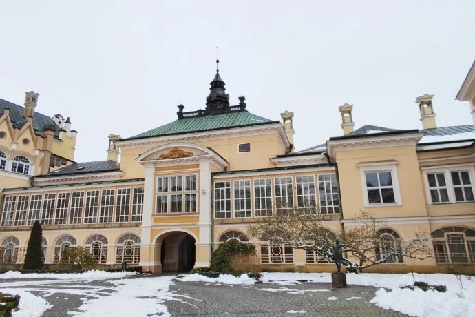 Zámek v Kyjově pokrytý sněhem na pozadí zasněné zahrady.