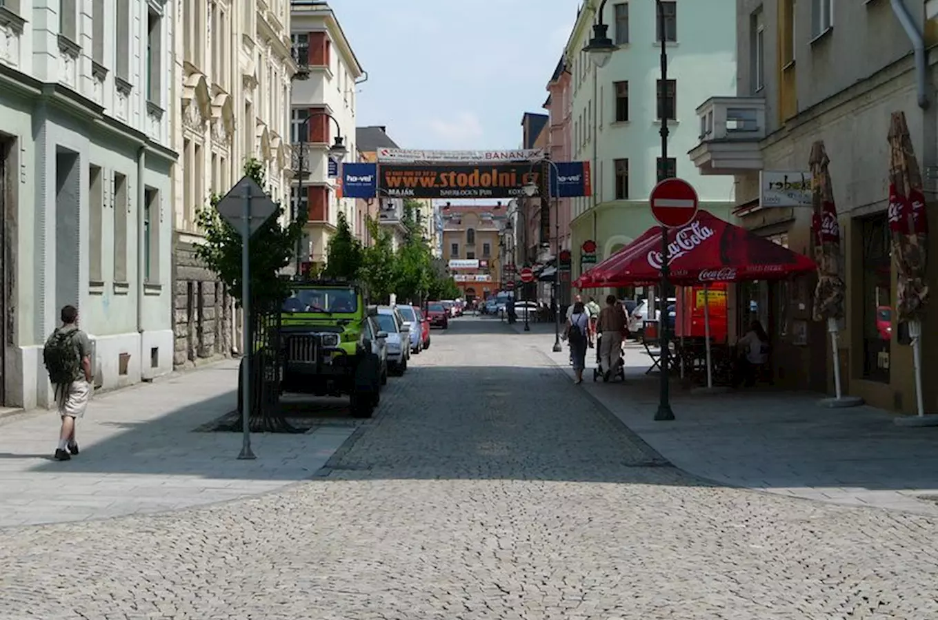 Stodolní ulice v Ostravě s barem a chůzci na slunci.