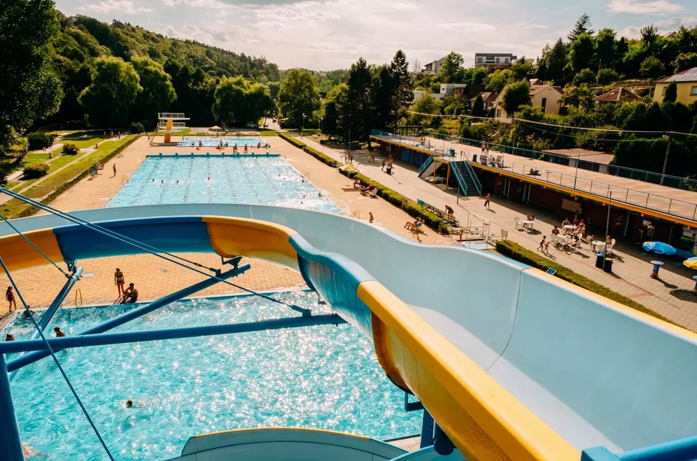 Venkovní bazén s vodním skluzavkou v Třebíči na sluneční den