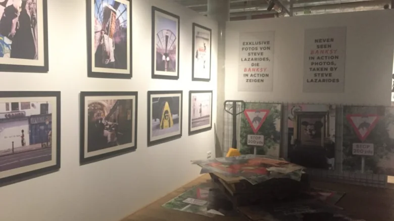 Výstava umění Banksy v pražské galerii s fotkami na stěnách.
