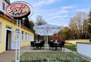 Venkovní terasa kaviáru Café Praha s zahradním nábytkem.
