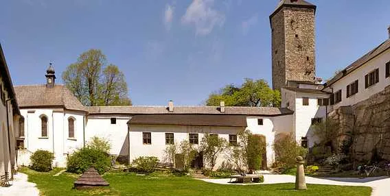 Dvůr hradu v Telči s věží a zelenou travou.