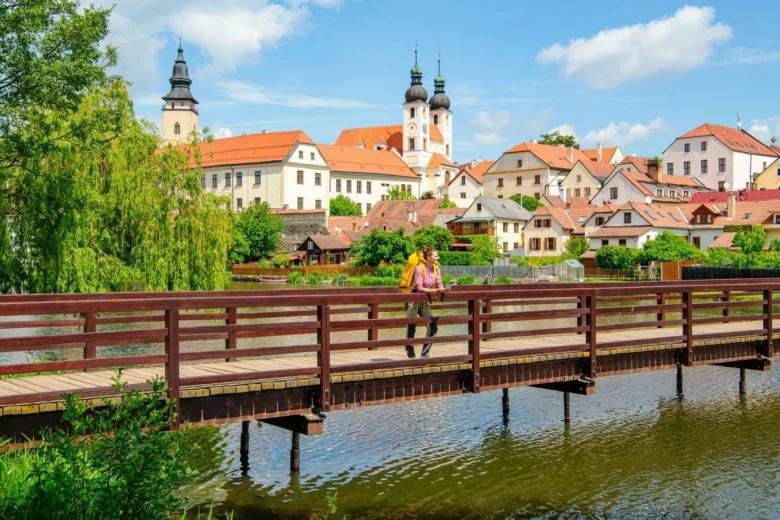 Turista kráčí po mostě v centru historického města Telče.