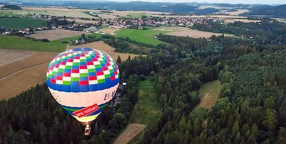 Horkovzdušný balón letí nad lesy u obce Křimice
