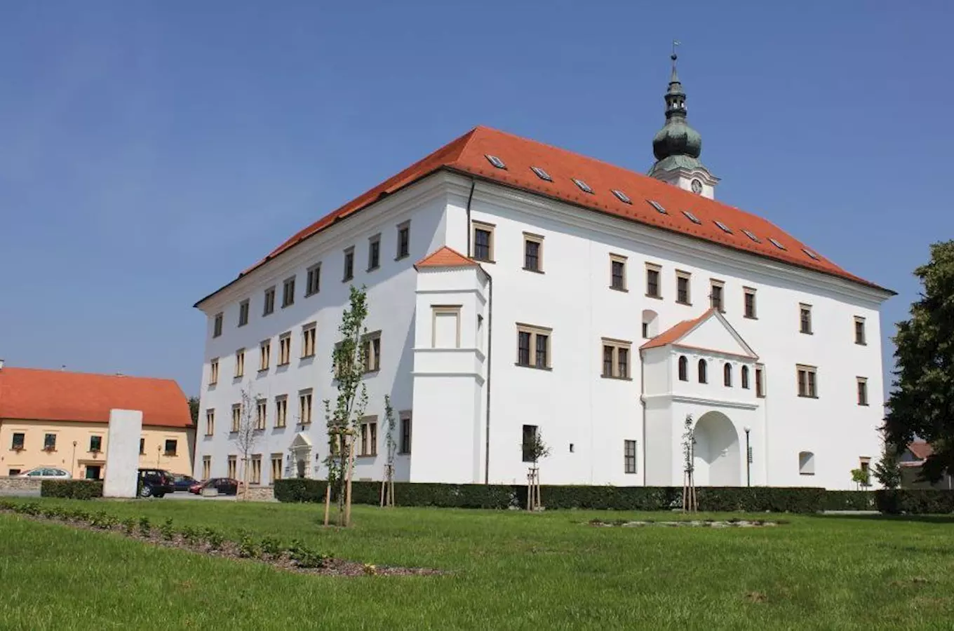 Zámek v Uherském Ostrohu na pozadí zelené trávy.
