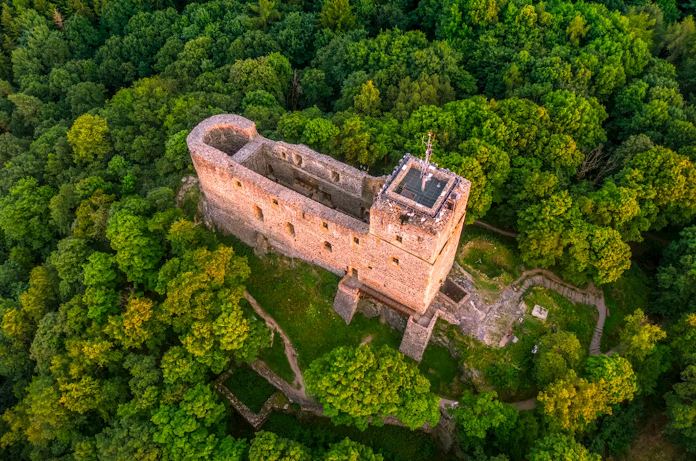 Záběr z výšky na ruiny hradu Radyně v lese.