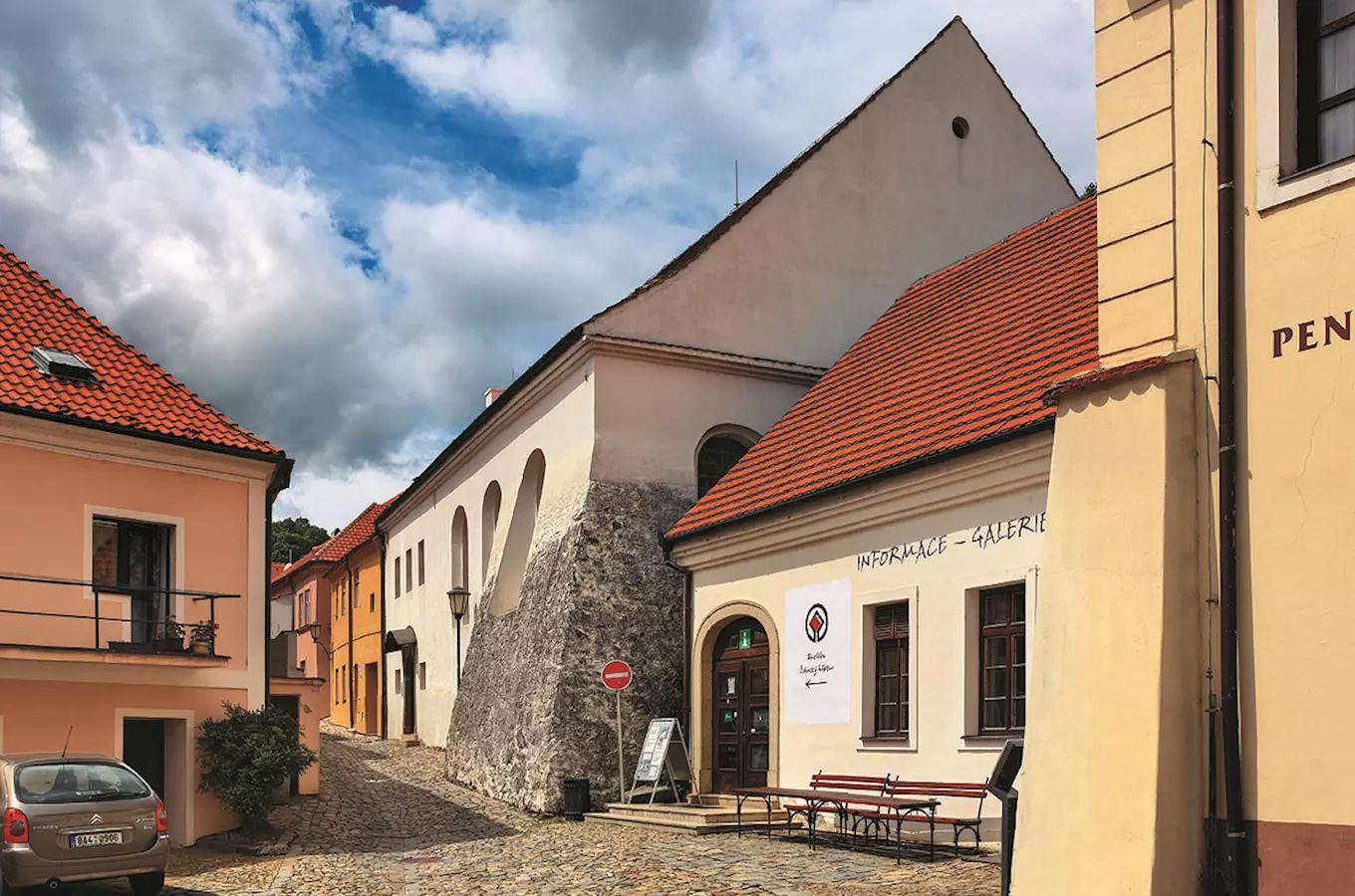Historické budovy na kamenné ulici v Třebíči s informační galerií.