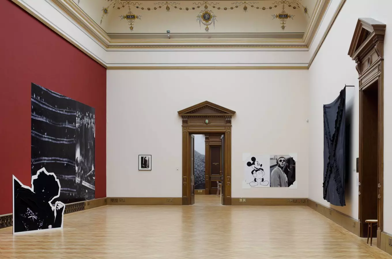 Výstava umění v historické síni Galerie Rudolfinum s instalacemi na zdi a podlaze.